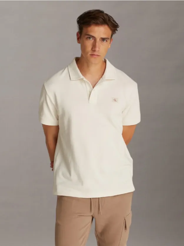  قميص بولو مزين بملصق شعار كلفن كلاين بحروف CK